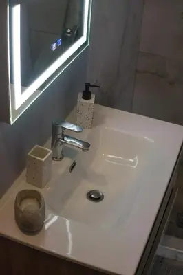 a bathroom sink with a toilet and a mirror at Paradise Apartment, Lardos Village in Lardos
