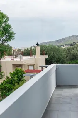 a white balcony with a view of a house at Paradise Apartment, Lardos Village in Lardos