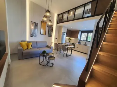 a living room with a couch and a kitchen at Koloniale Loft House in Rhodes Town