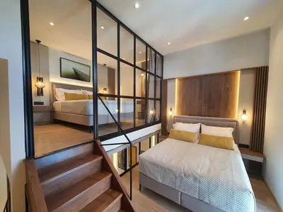a small bedroom with a bed and a staircase at Koloniale Loft House in Rhodes Town