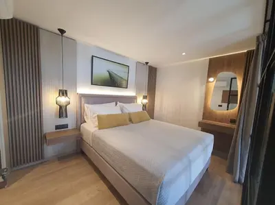 a bedroom with a large white bed and a mirror at Koloniale Loft House in Rhodes Town