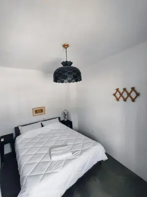 a bedroom with a white bed and a chandelier at Απόλλων in Apóllona