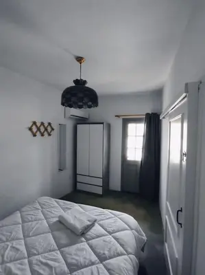 a bedroom with a white bed and a window at Απόλλων in Apóllona