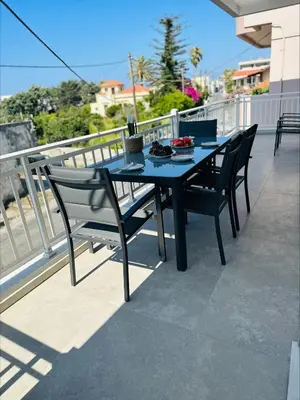 a black table and chairs on a balcony at Flev's House with Jacuzzi & Rooftop BBQ in Kremasti