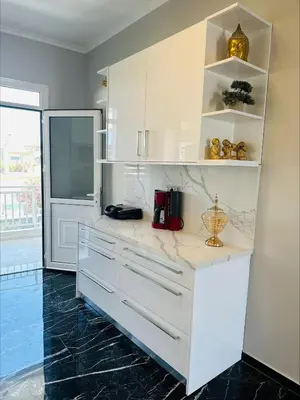 a kitchen with white cabinets and a counter top at Flev's House with Jacuzzi & Rooftop BBQ in Kremasti