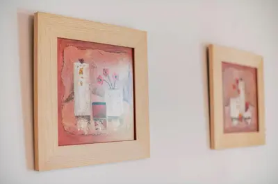 two framed pictures of vases on a wall at Alonia View House in Asklipiḯon