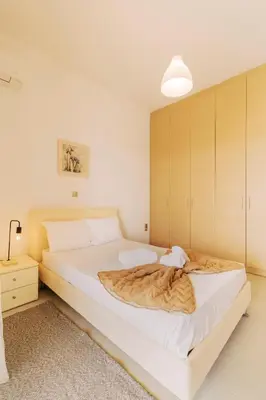 a bedroom with a large bed with a blanket on it at Alonia View House in Asklipiḯon