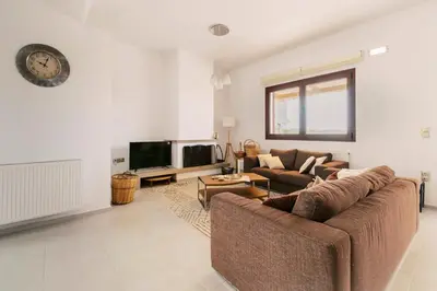 a living room with a couch and a tv at Alonia View House in Asklipiḯon