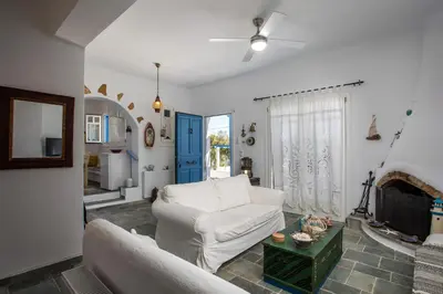a living room with a white couch and a fireplace at Traditional Greek Island Summer at Villa Julia in Kolimbia