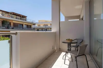 a small balcony with a table and two chairs at Alpha Urban Suites in Rhodes Town