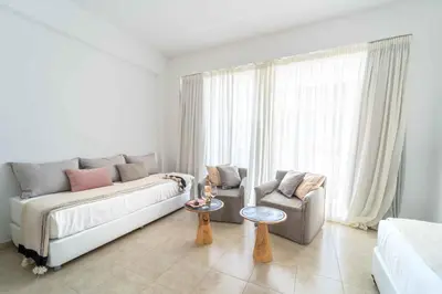 a living room with a couch and a chair at Alpha Urban Suites in Rhodes Town
