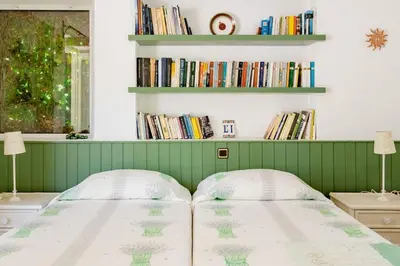 a bed in a room with bookshelves at Los Olivos V.I.P Poolvilla Kritinia in Kamiros