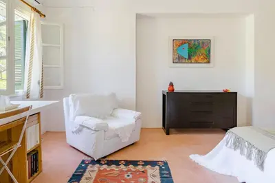 a white chair in a room with a bedroom at Los Olivos V.I.P Poolvilla Kritinia in Kamiros