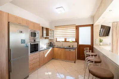 a kitchen with wooden cabinets and stainless steel appliances at Vista Magica in Pastida
