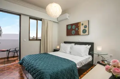 a hotel room with a bed with a green blanket at Luciana City Apartment in Rhodes Town