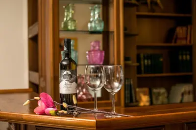 a bottle of wine and two wine glasses on a counter at Luciana City Apartment in Rhodes Town