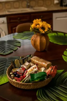 a table with a basket of food and a vase with flowers at Luciana City Apartment in Rhodes Town