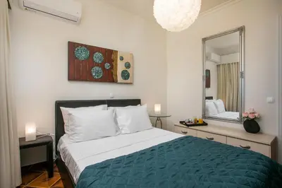 a bedroom with a large bed and a mirror at Luciana City Apartment in Rhodes Town