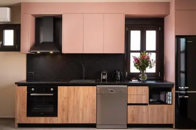 a kitchen with black and white cabinets and a refrigerator at Fluvian Terrace in Rhodes Town