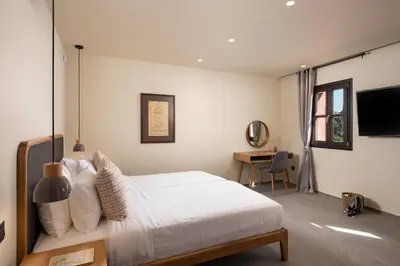 a bedroom with a white bed and a desk at Fluvian Terrace in Rhodes Town