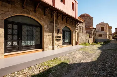 a brick building with a black door on a street at Fluvian Terrace in Rhodes Town