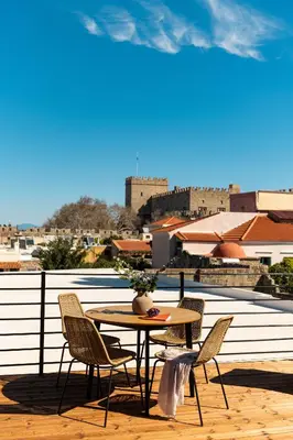 a table and chairs on a balcony with a view at Fluvian Terrace in Rhodes Town