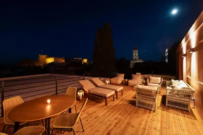 a rooftop deck with a table and chairs and a couch at Fluvian Terrace in Rhodes Town