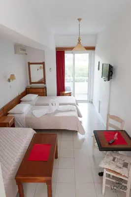 a hotel room with two beds and a living room at Let it Be Apartments in Theologos