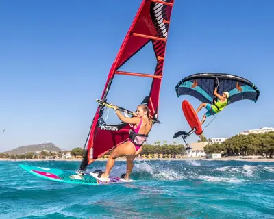 two people are windsurfing in the ocean on the water at Let it Be Apartments in Theologos