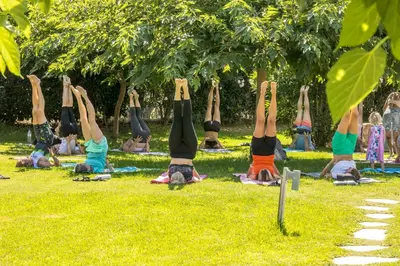 a group of people doing yoga in the grass at Let it Be Apartments in Theologos