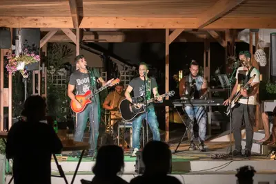 a group of men playing music on a stage at Let it Be Apartments in Theologos