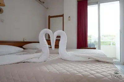 two swans made out of towels on a bed at Let it Be Apartments in Theologos