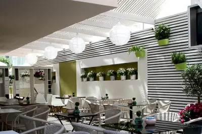 a restaurant with tables and chairs and potted plants at Svea Hotel in Rhodes Town