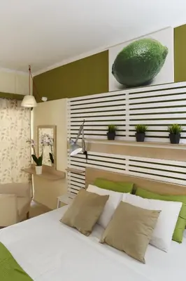 a bedroom with a bed with a large green bowl on the wall at Svea Hotel in Rhodes Town