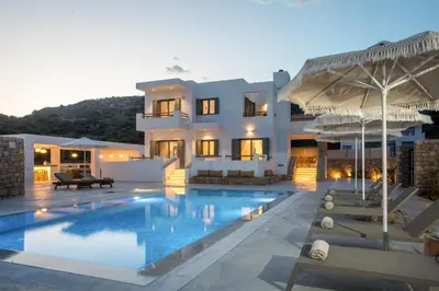 a villa with a swimming pool at dusk at Villa Elaia in Afantou