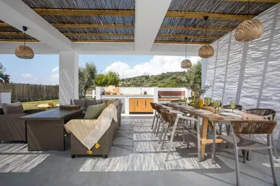 an outdoor patio with a table and chairs at Villa Elaia in Afantou