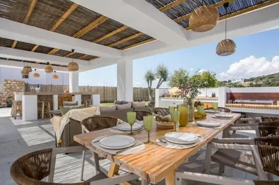 an outdoor dining area with a wooden table and chairs at Villa Elaia in Afantou