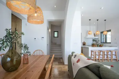 a dining room and living room with a wooden table at Villa Elaia in Afantou