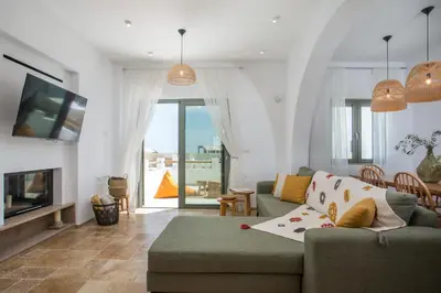 a living room with a couch and a tv at Villa Elaia in Afantou