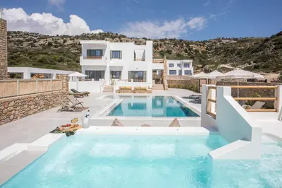 a villa with a swimming pool in front of a house at Villa Elaia in Afantou
