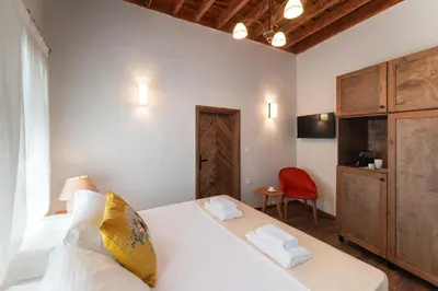 a bedroom with a white bed and a red chair at Rodos Old Town Aqua Luxury House in Rhodes Town