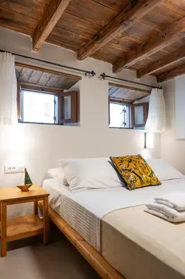 a bedroom with two beds and a table and two windows at Rodos Old Town Aqua Luxury House in Rhodes Town