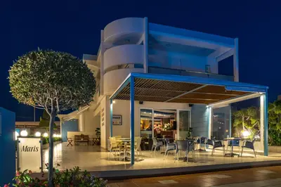 a house with a deck at night at Sun Maris in Faliraki