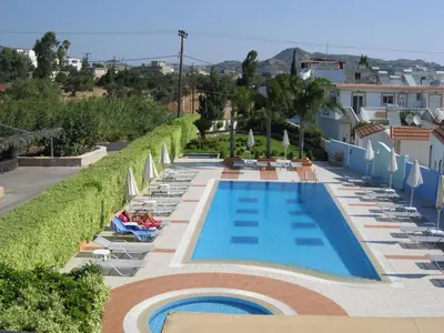 a swimming pool with lounge chairs and umbrellas at Sun Maris in Faliraki