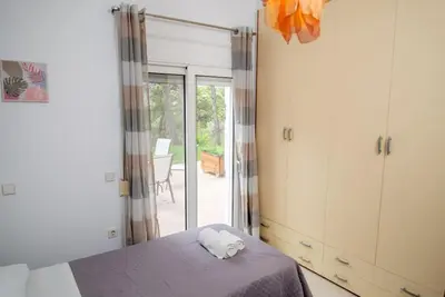 a bedroom with a bed and a sliding glass door at Pines Villa in Rhodes Town