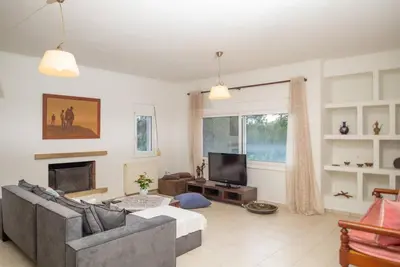 a living room with a couch and a tv at Pines Villa in Rhodes Town