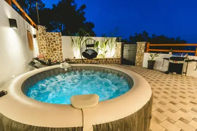 a jacuzzi tub in a backyard at night at Casa Zoe Luxurious Retreat in Archangelos