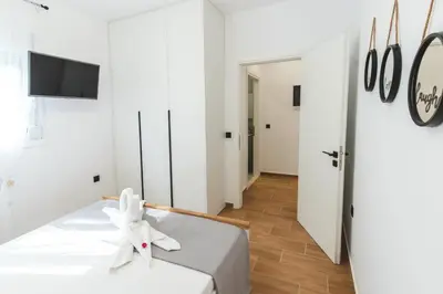 a white room with a bed and a tv at Casa Zoe Luxurious Retreat in Archangelos