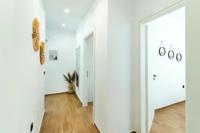 a hallway with white walls and wood flooring at Casa Zoe Luxurious Retreat in Archangelos
