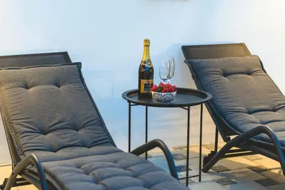 two chairs and a table with a bottle of wine at Casa Zoe Luxurious Retreat in Archangelos